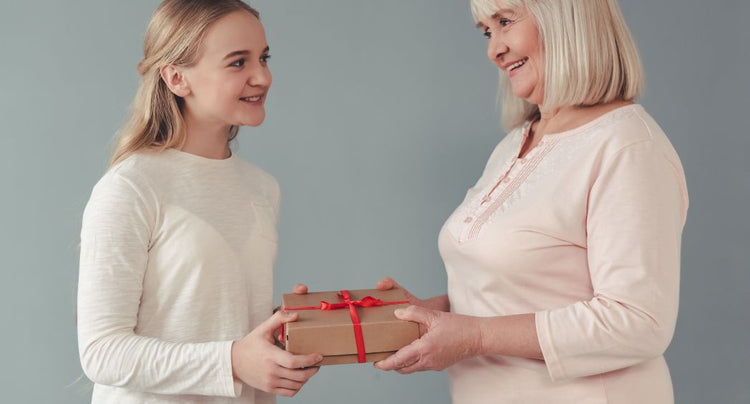 grandma giving granddaughter a gift box